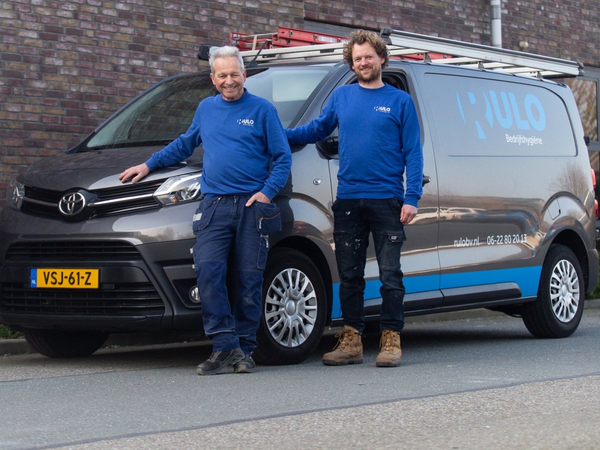 Twee medewerkers van RULO bij hun bedrijfsbus